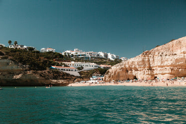 limestone hills peppered with houses overlook a sandy beach