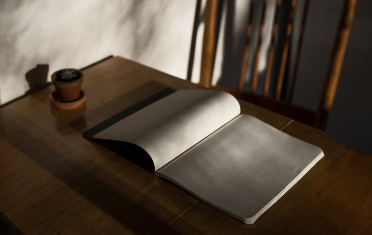 lined notebook lays open on a wooden table