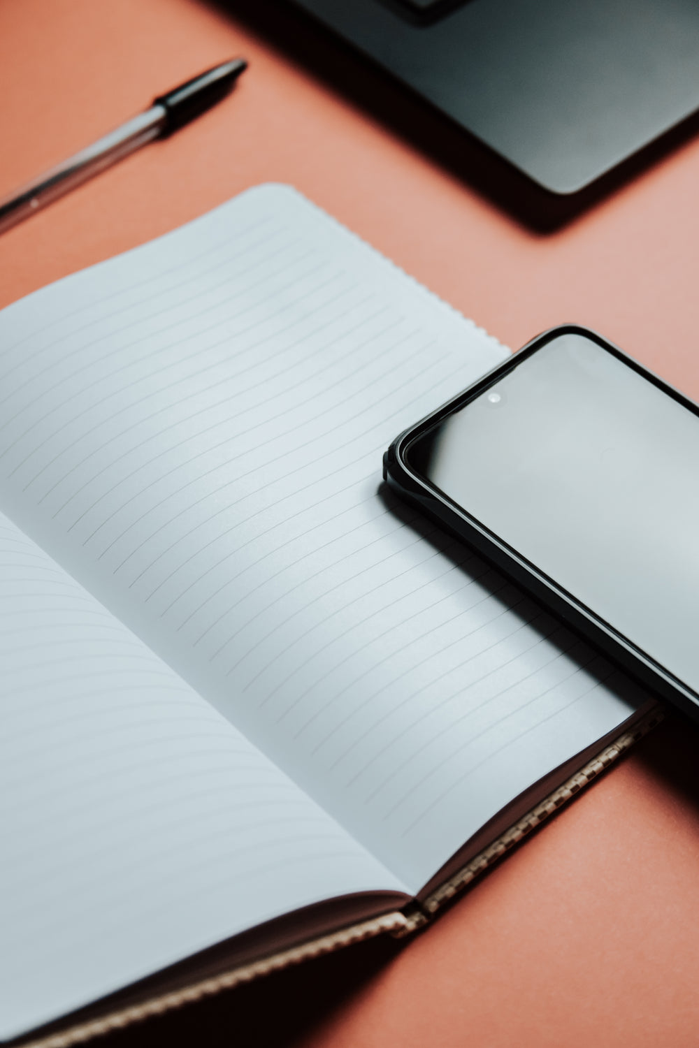 lined notebook with a cellphone resting on it