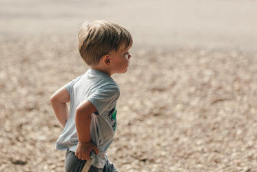 little blond boy running holding his pants up