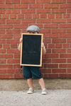 little boy holding blank chalkboard