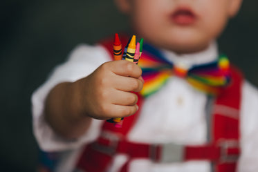 little boy holding crayons