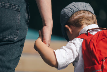 little boy holding moms hand