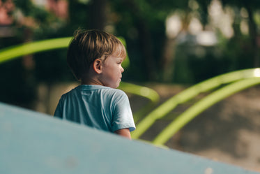 menino no parque olhando para a direita