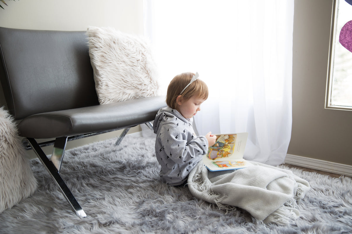 little girl under a blanket reading