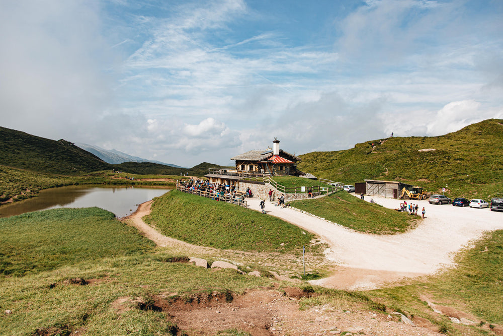 log cabin overlooking pond surrounded by people