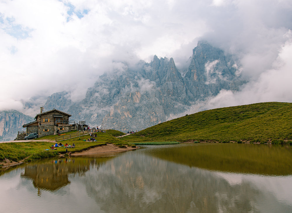 log cabin reflected in pond backed by mountains