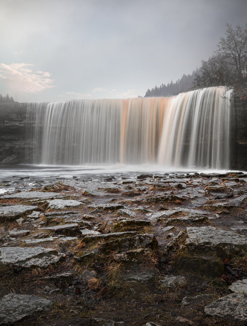 long exposure of a waterfall with wet brown stones