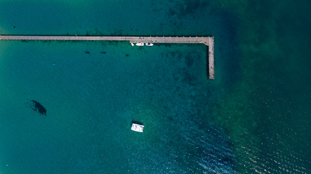 long wooden pier on blue ocean