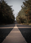 look down the white line of a paved road