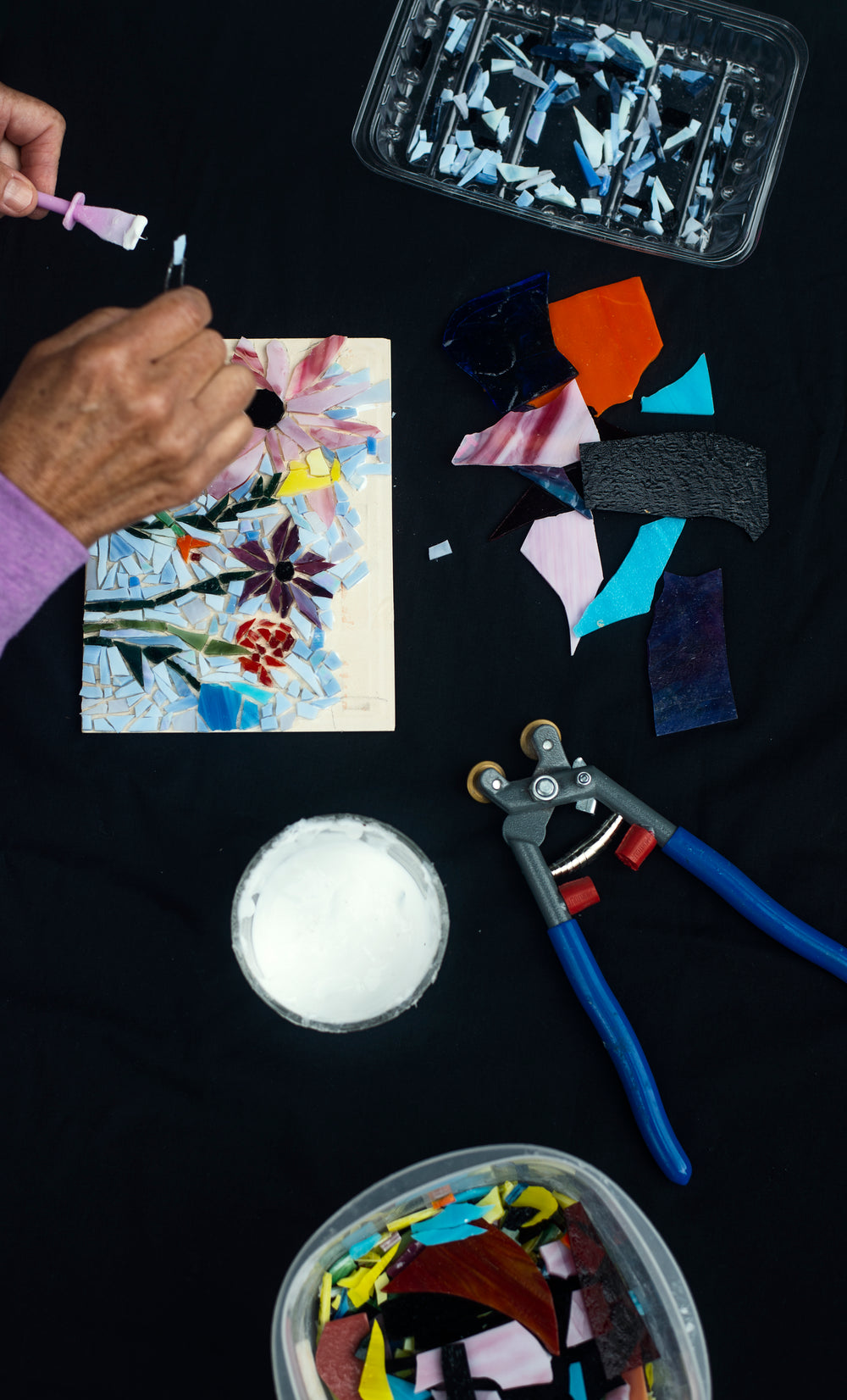 looking down at mosaic artist making floral design