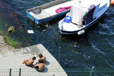 looking down at three people sitting by docked boats