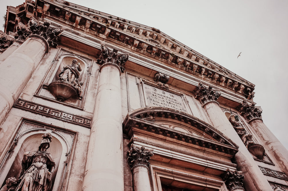 looking up a buildings with alcoves and sculptures