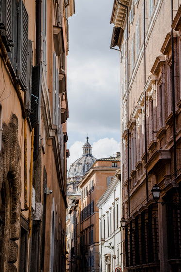 looking up at thin alley lined with tall buildings