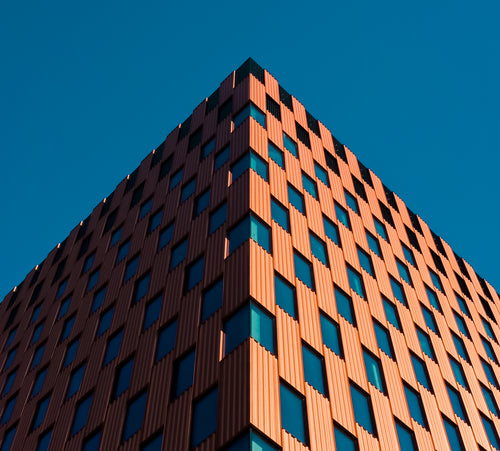 looking up the the corner of a checkered building