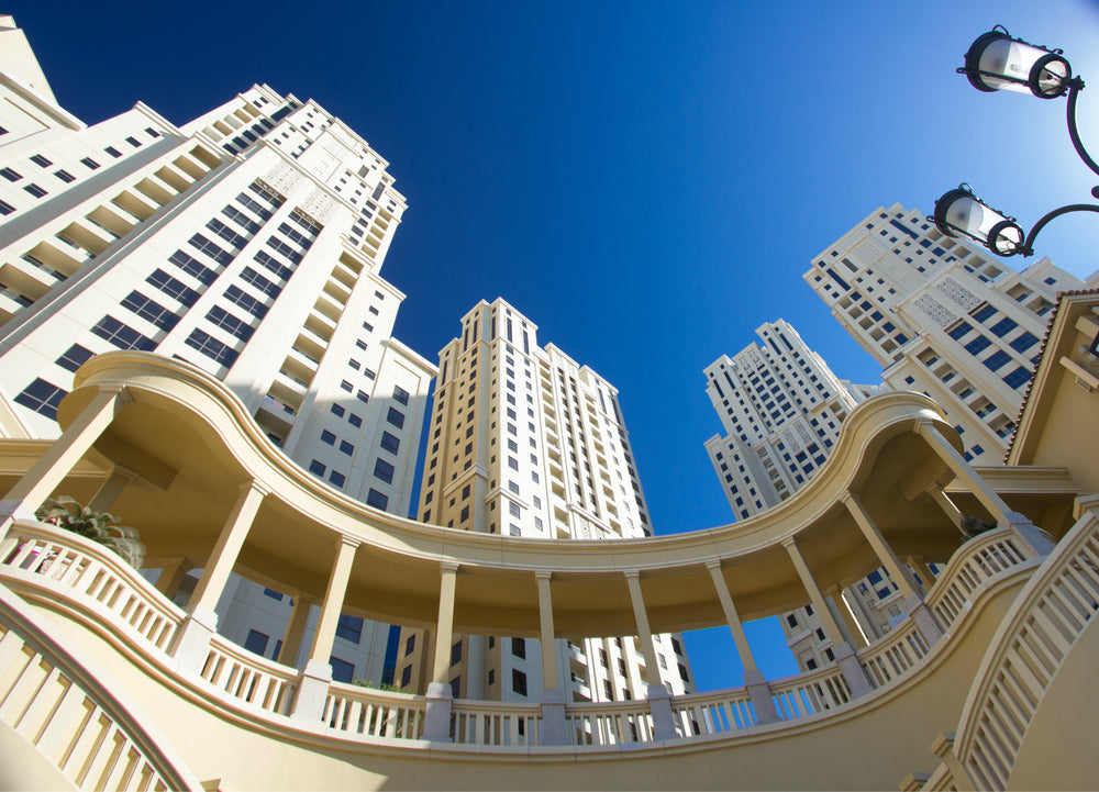 looking up toward tall buildings under blue sky