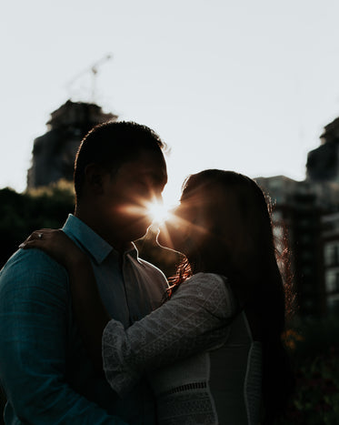 amantes se abraçam com o pôr do sol ao fundo