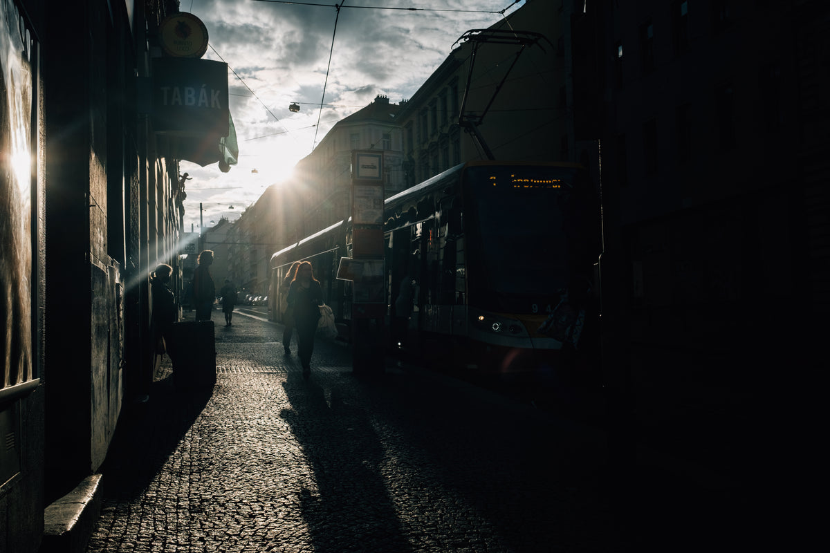 low sun silhouetted people on a city street