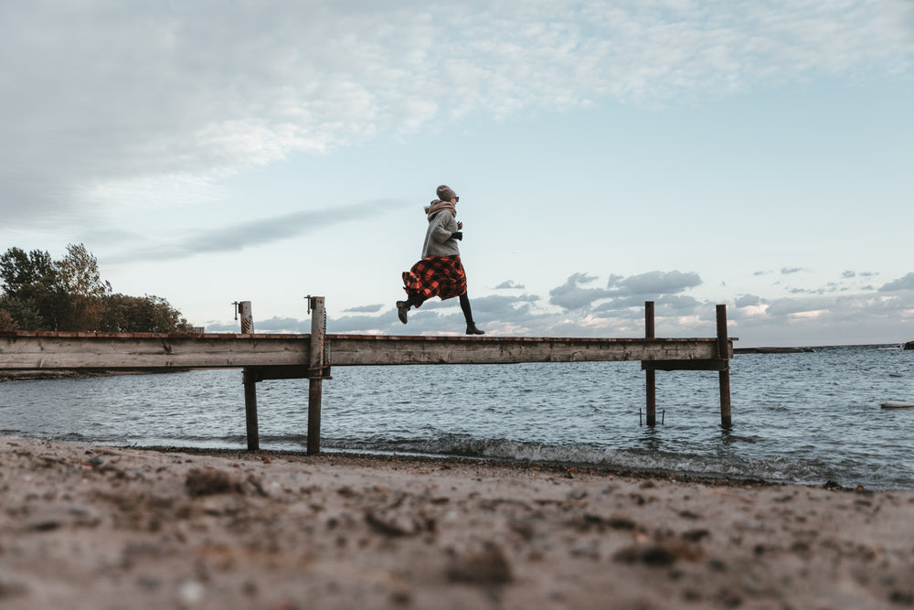 low view of a young woman running across dock