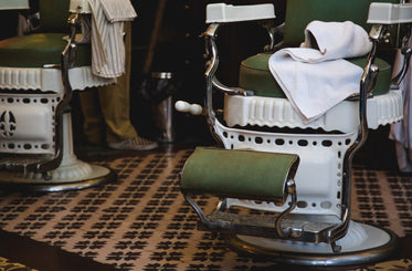lower view of green and white chairs in barbershop
