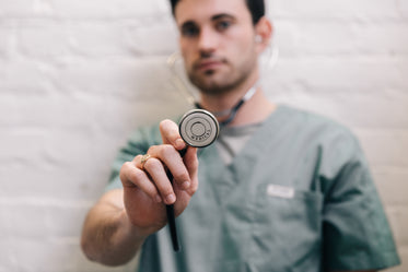 male doctor holding out stethoscope