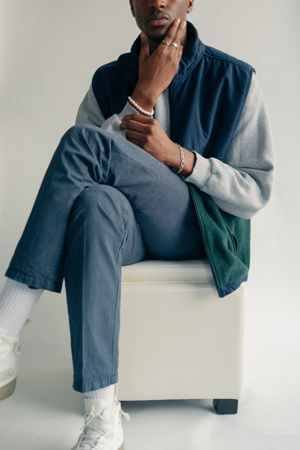 male model cross legged on white cushion