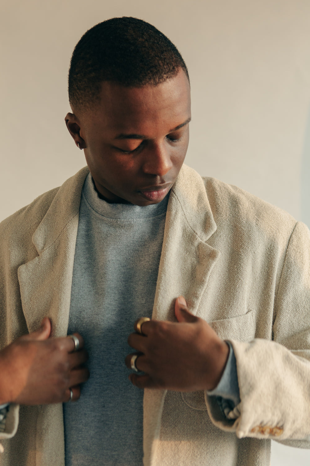 man adjusting light tan overcoat