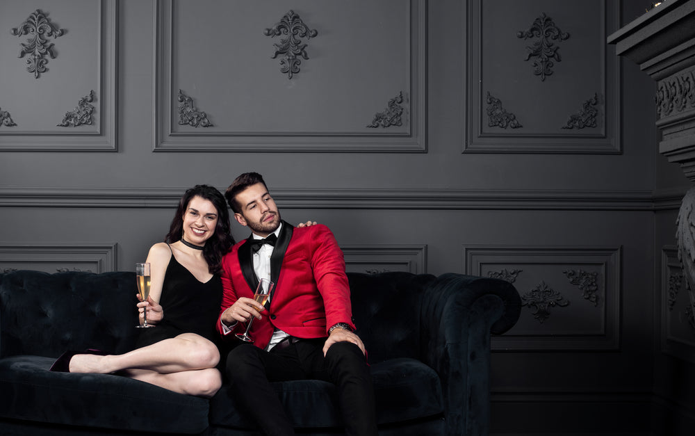 man and woman in fancy dress pose on couch