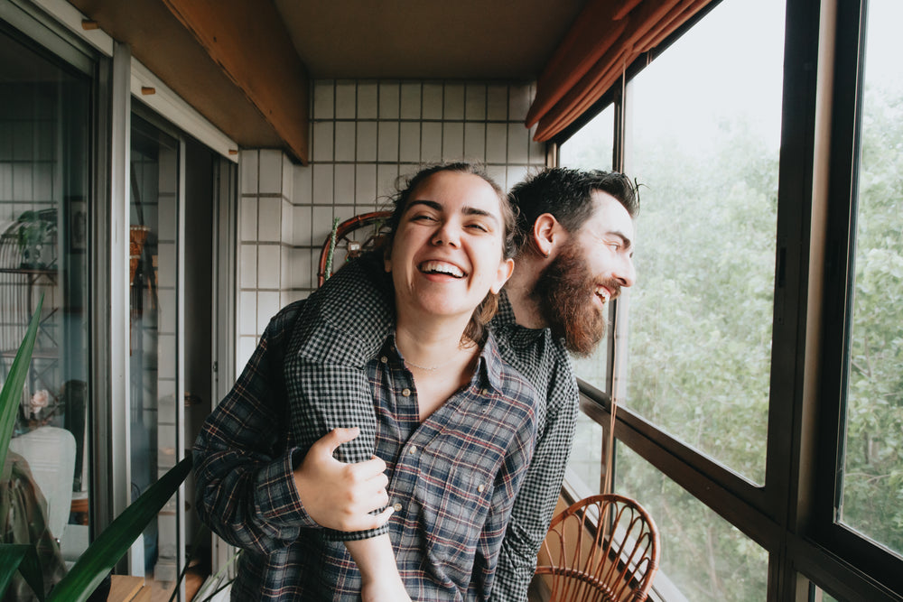 man and woman smile together standing in a solarium