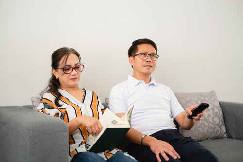 man and woman together sitting on grey couch