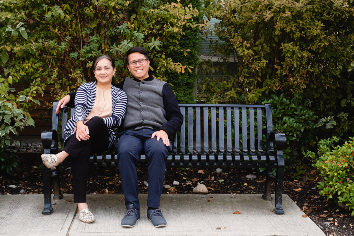 man and woman together smile on park bench