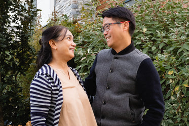 man and women looking at each other in front of vines