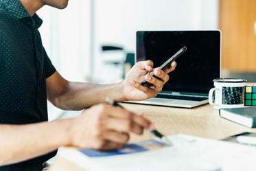 man at desk looking at his mobile