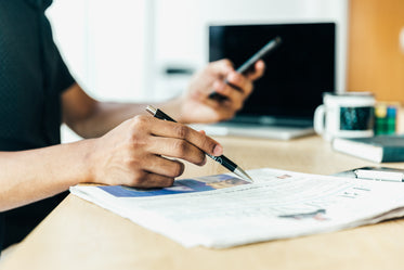 man at desk looking at his newspaper