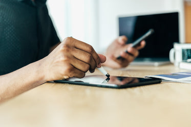 man at desk writing on ipad with stylus