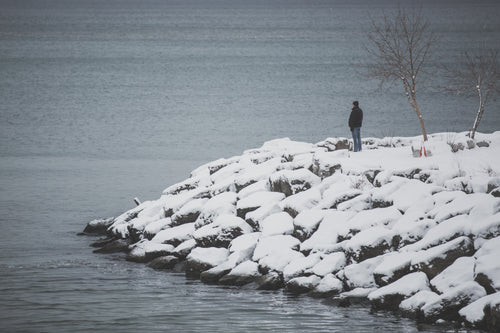 man at snowy waters edge