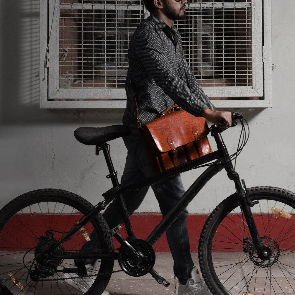 man biking with leather messenger bag