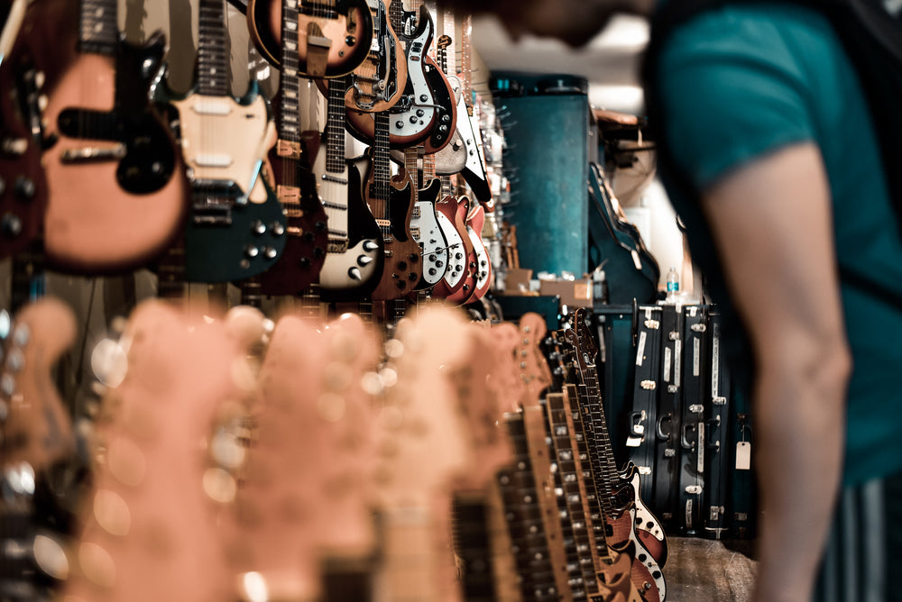 man browsing at a guitar shop