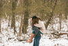 man carries his girlfriend on his back threw the snow