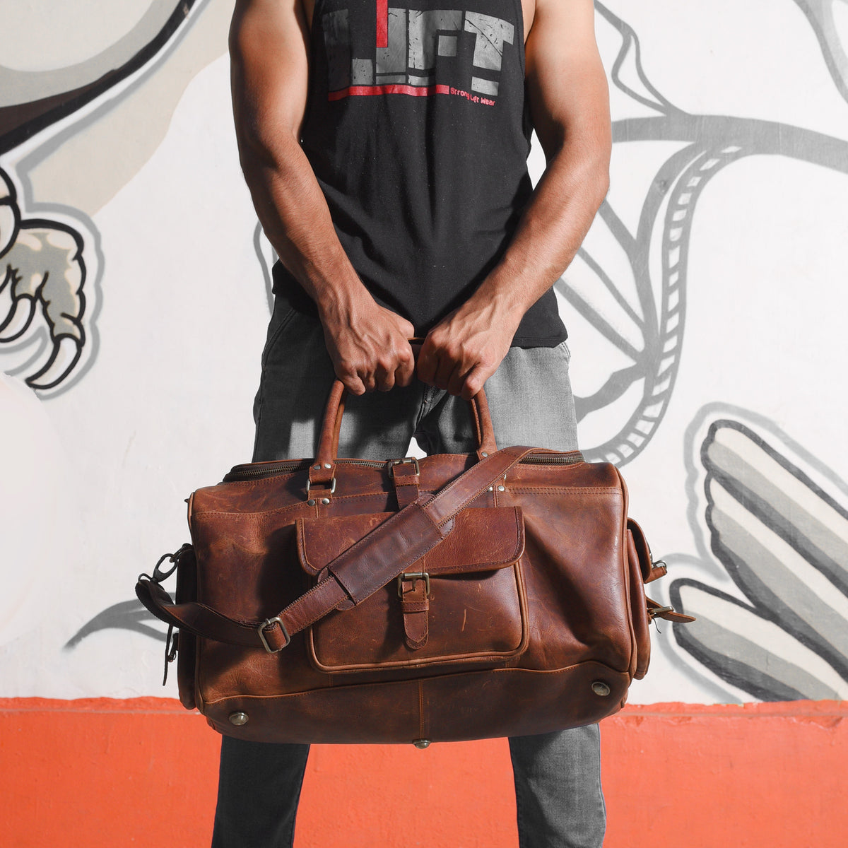 man clutching his leather duffle bag