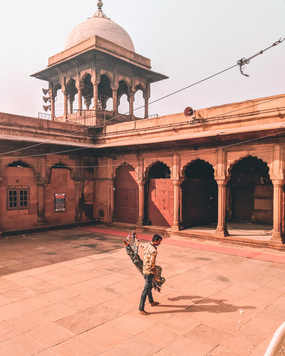 man crosses courtyard