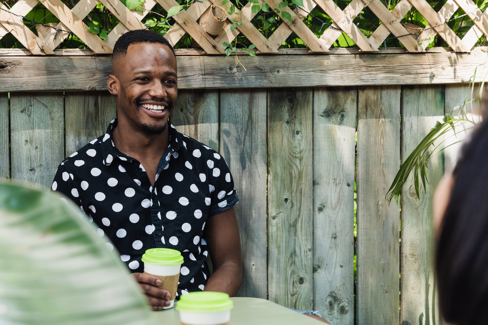 man drinking coffee in polkadot shirt