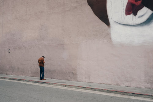 man facing wall & texting