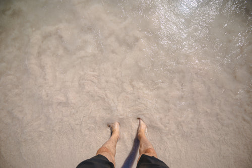man feet in beach water
