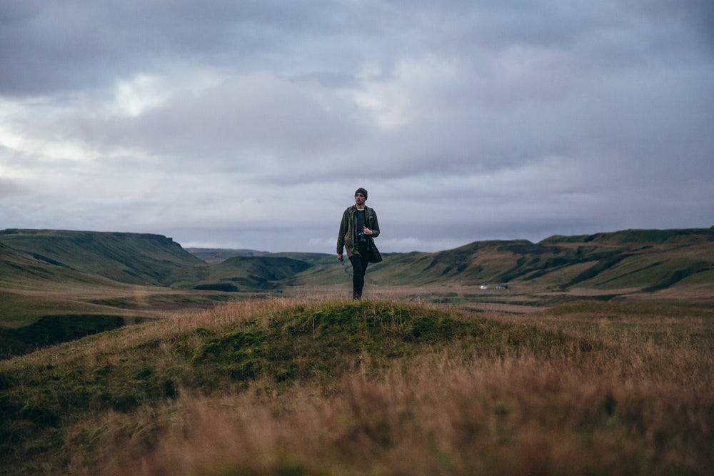 man hikes hilly landscape