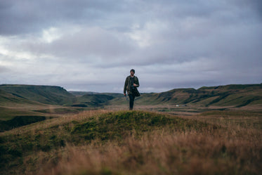 man hikes hilly landscape