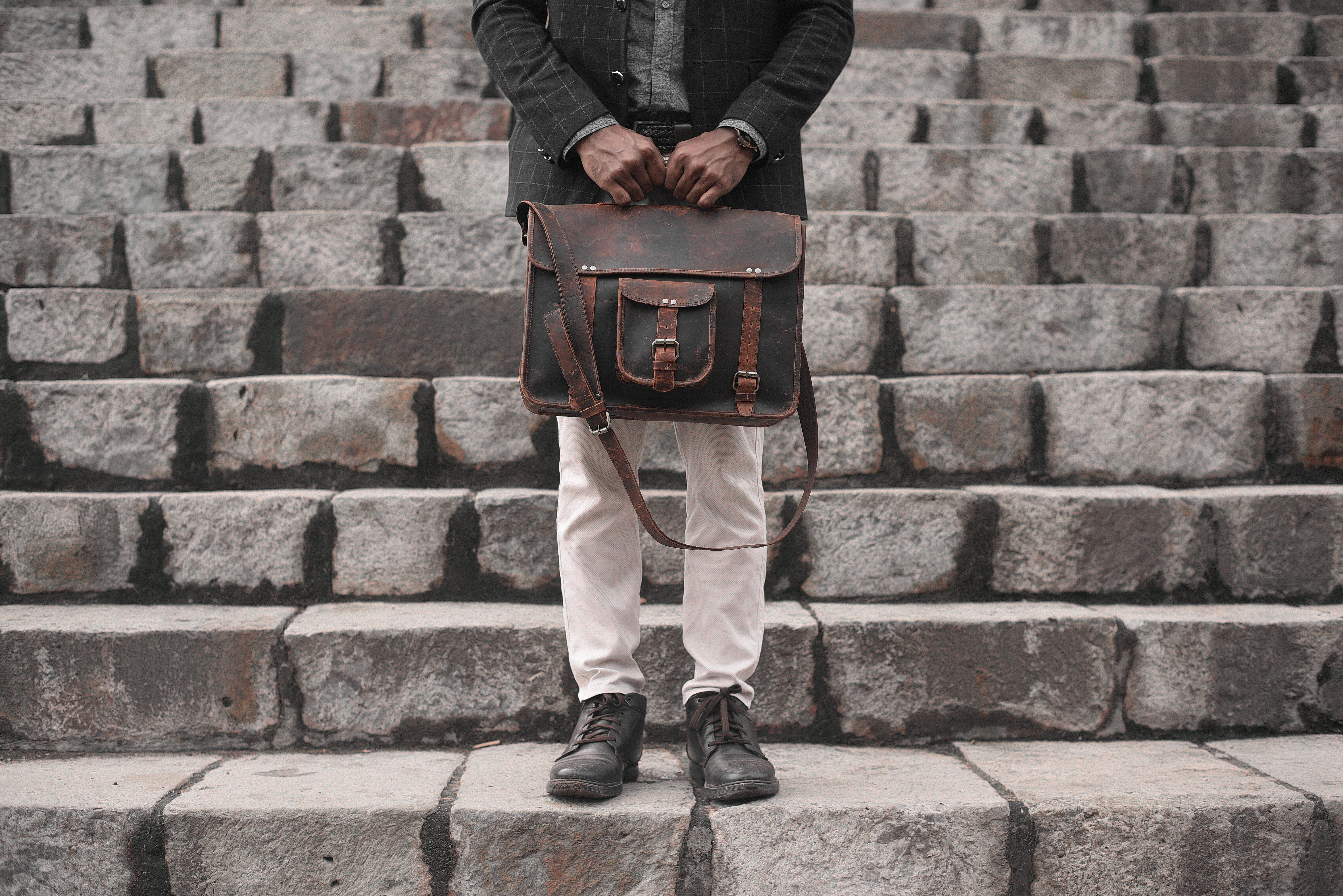 Man Holding A Leather Bag On A Set Of Stairs