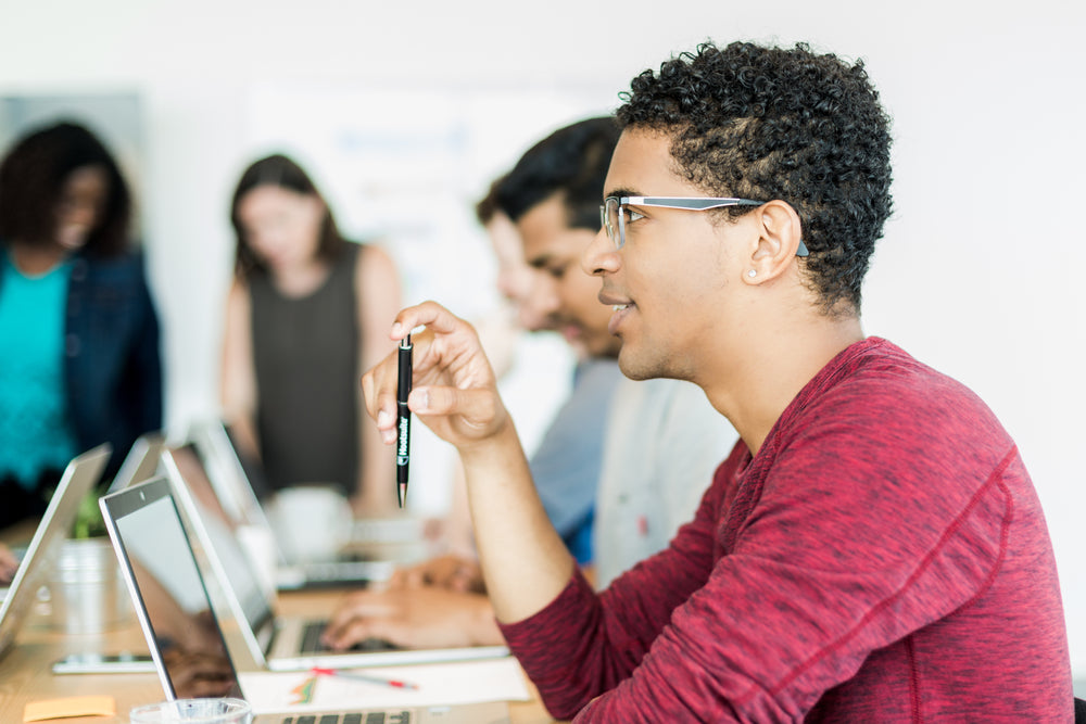 man holding pen in meeting