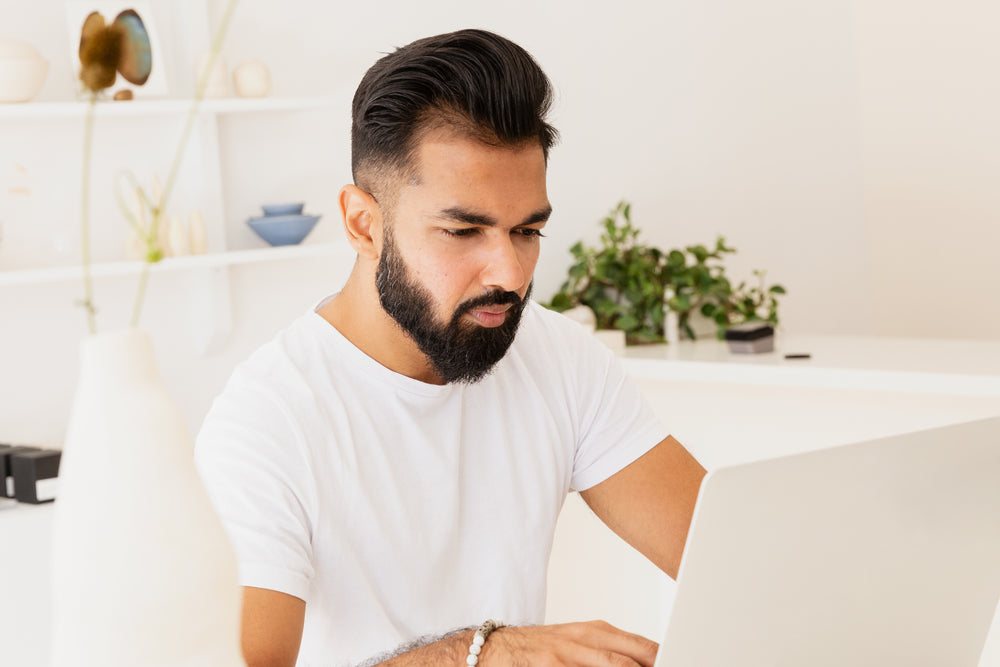 man in bright store working on laptop