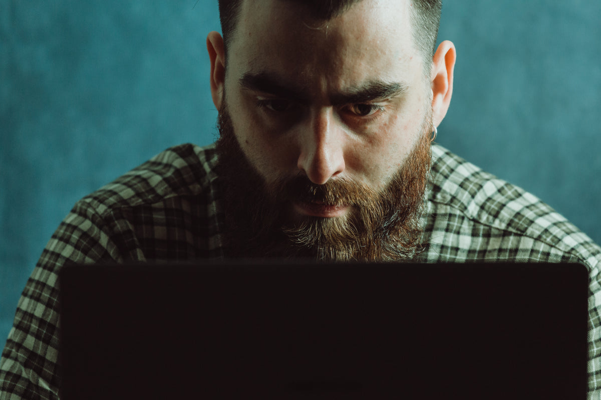 man in deep concentration looks down at a laptop